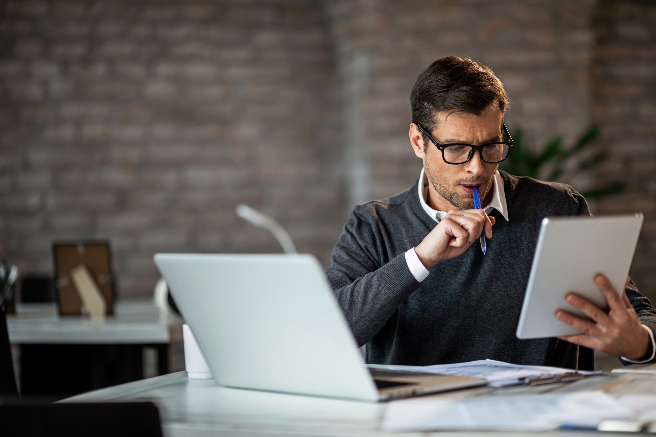 Предприниматель использующий. Skilled visa. Skilled worker visa. Business man using a Touchpad to view his e-mails on his Desk at the Office.. Office Manager reading an email.